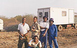 Afrikanische Mitarbeiter vor Fahrzeugen