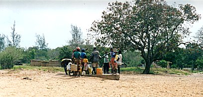 Menschen an einem Brunnen am Ortsrand